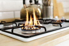 Macro Closeup Of Modern Luxury Gas Stove Top With Blue Fire Flame Knobs Bokeh Blurry Blurred Background