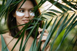 © Roman - portrait of sensual beautiful attractive young woman in forest, standing next to green plants. short haired brunette lady around tropical exotic plants. botanic, forest, wildlife and people concept