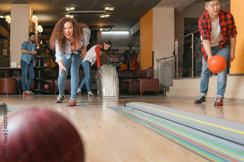 Friends playing bowling in club