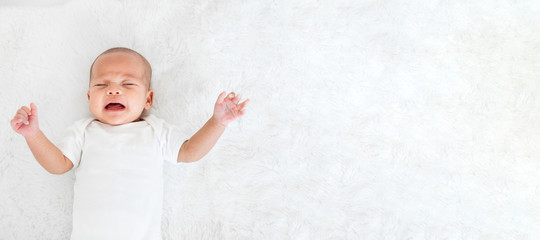 Portrait newborn baby crying sickness/illness over white background, topview