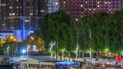 Wall Mural - Seine river with ship in Paris at night timelapse, waterfront of the seine river in the city of Paris in france