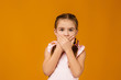 © producer - Cute little child girl closes her eyes with her hand on yellow background. I see nothing