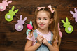 © producer - happy little child girl holding painted Easter eggs. Easter day