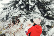 © hetmanstock2 - Cute family have fun in a winter park. Woman in a red jacket.