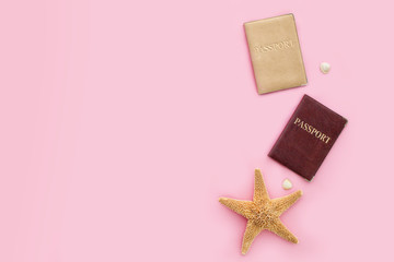 Two passports and starfish on a pink background. Travel concept.