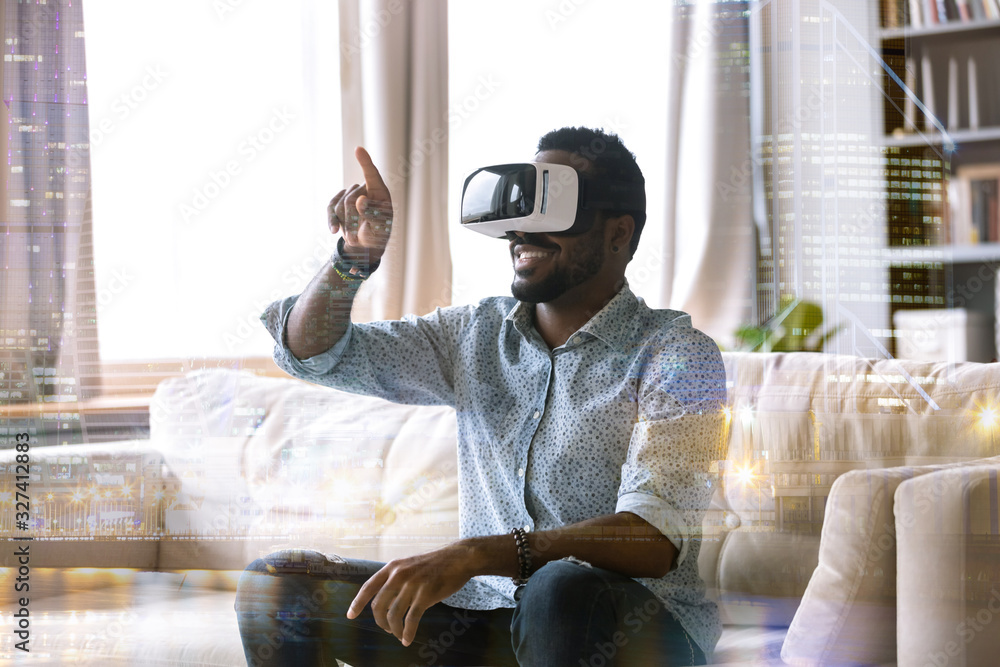 Excited young african american man wearing virtual reality glasses ...