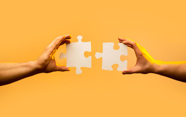 closeup hand of connecting jigsaw puzzle. business solutions, success and strategy concept. two hand