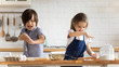 Little siblings preparing dough baking in kitchen together