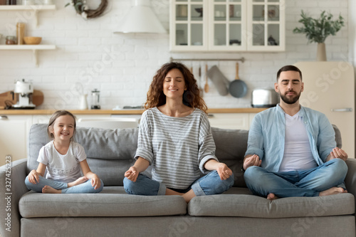 Fotomural Young family with little daughter practice yoga together