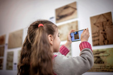 Curious Girl Exploring A Contemporary Art Exhibition With Augmented Reality Mobile Application