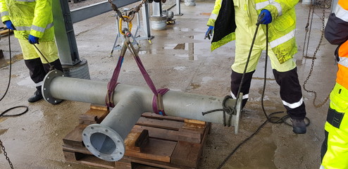 riggers move the pipe using two chain blocks