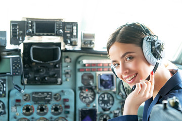 Young friendly operator woman agent with headsets working in a avia call centre. Operatore in avia company persons crew pilots stewardess airplane command civil aviation.