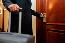 Ready To Experience Real Comfort. Cropped Shot Of Middle-aged Businessman In Coat With Suitcase Opening The Door Using Key Card While Entering His Room In A Luxury Hotel