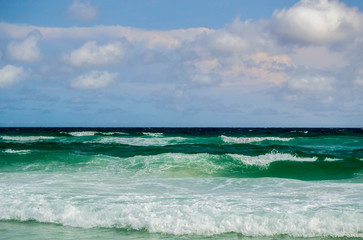 Deep green waves rolling into shore