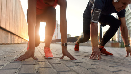 Wall Mural - Cropped photo of a couple in sports clothing standing on the start line while running together outdoors