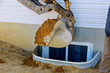 Excavator moving earthmover in the new house under construction window well basement construction