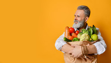 Cool Old Mature Senior Man With Gray Beard Shopping Hold Grocery Shopping Bag With Healthy Organic Vegetables On Yellow