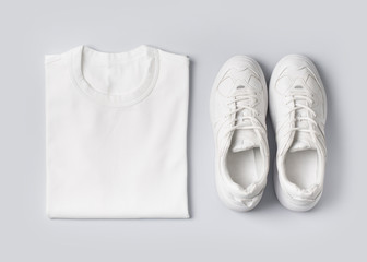 Fashion female clothes on white background. Basic T shirt and sneakers.