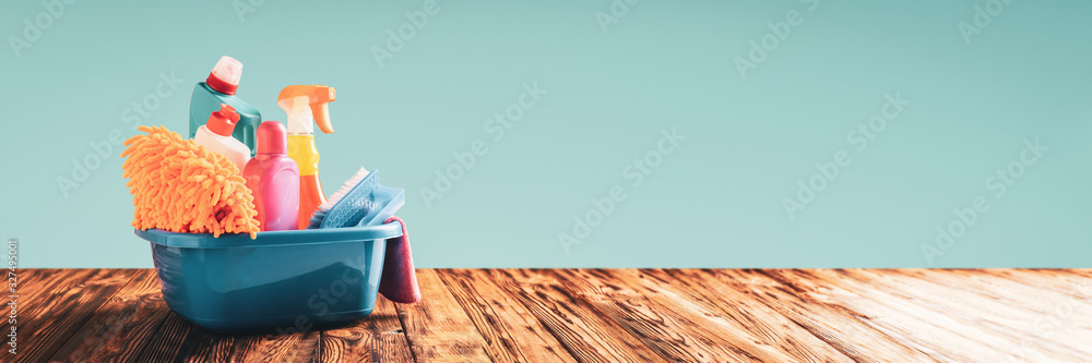 Cleaning items in a basin on a wooden table web banner with copy space: spring cleaning concept - obrazy, fototapety, plakaty 