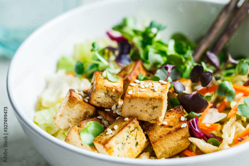 Fried tofu salad with sprouts and sesame seeds in white bowl. Vegan food, asian food concept. - obrazy, fototapety, plakaty 
