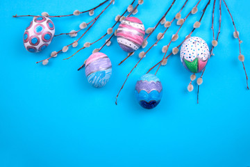 Wall Mural - Easter eggs on tree branches with buds on a blue background