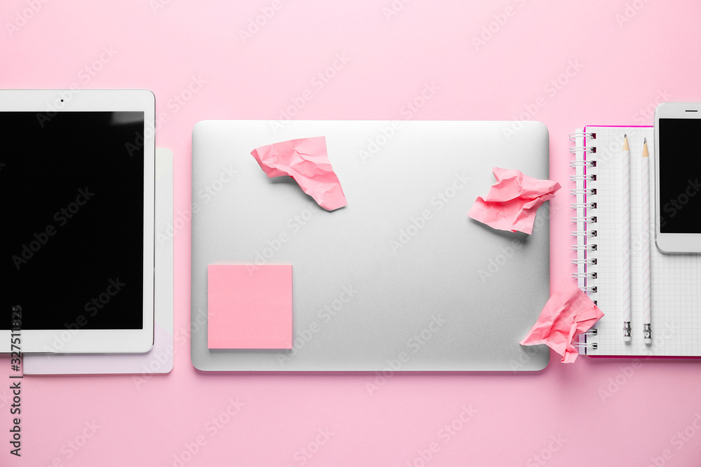 Modern devices with stationery on pink background