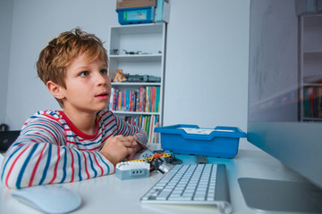 Wall Mural - child building and programming robot on computer