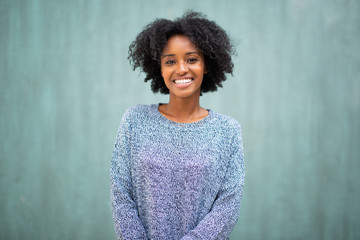 Wall Mural - portrait smiling young black woman by green background