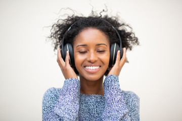 Wall Mural - Front portrait young african american woman listening to music with headphones and eyes closed