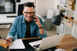 © JustLife - Businessman in office. Handsome man talking on phone at work.
