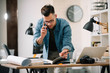 © JustLife - Businessman in office. Handsome man talking on phone at work.