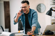 © JustLife - Businessman in office. Handsome man talking on phone at work.