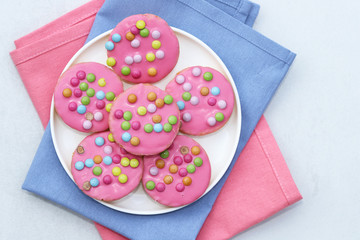 Wall Mural - Pink cookies with colorful smarties.