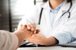 © PORNCHAI SODA - Doctor hands together holding senior woman patient