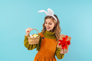 Poster - Photo of joyful blonde girl holding basket with eggs and gift box