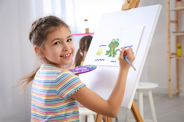 Sticker - Cute little child painting during lesson in room