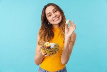 Portrait Of Excited Young Woman Holding Basket With Painted Easter Eggs