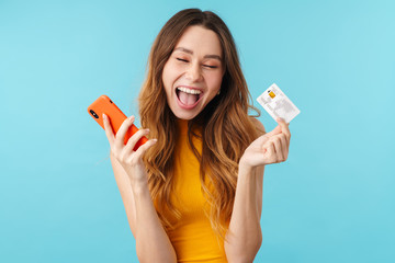 Sticker - Portrait of delighted caucasian woman holding cellphone and credit card