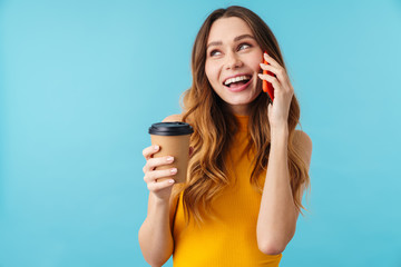 Wall Mural - Portrait of joyous woman holding coffee cup and talking on cellphone