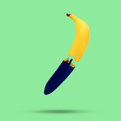 Painted flying banana cut on green background.