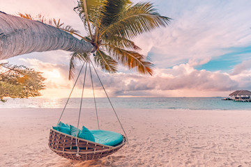Tropical beach sunset as summer landscape with luxury resort beach swing or hammock and white sand and calm sea for sunset beach landscape. Tranquil beach scenery vacation and summer holiday concept.