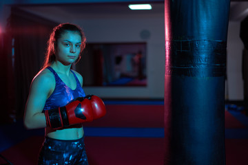 Wall Mural - Boxer girl hitting the heavy bag