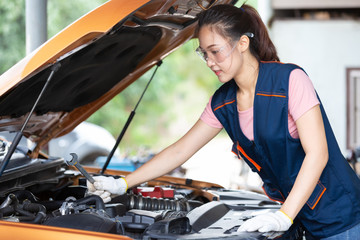 Female Mechanic checking car engine