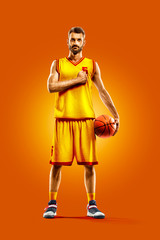 Wall Mural - bright professional basketball player on an orange background