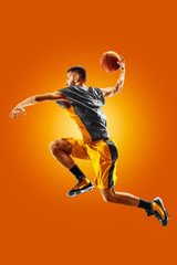 Wall Mural - bright professional basketball player on an orange background