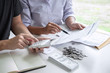 © Ngampol - Images of Husband and wife using calculator to calculating expenditure receipt bills of various activity cost and expenses in home office and written make report to plan of spent in future