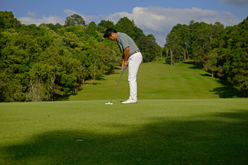 Golfer putting golf in beautiful golf course.