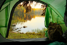 View From Inside A Tourist Tent With Backpack. Beautiful Scandinavian Landscape Of Forest And Lake. Finland