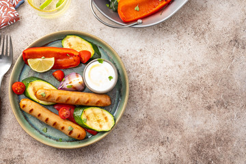 Wall Mural - Grilled sausages with vegetables and sauce. Summer concept.