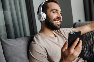 Poster - Positive man listening music with headphones